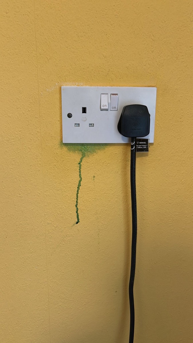 Socket outlet on a damp-damaged wall investigated during a fault-finding visit